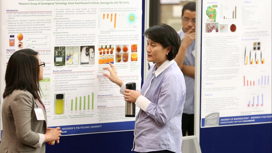 Professor Eun Joo Lee discusses a research project with a student at Research Day in 2015.