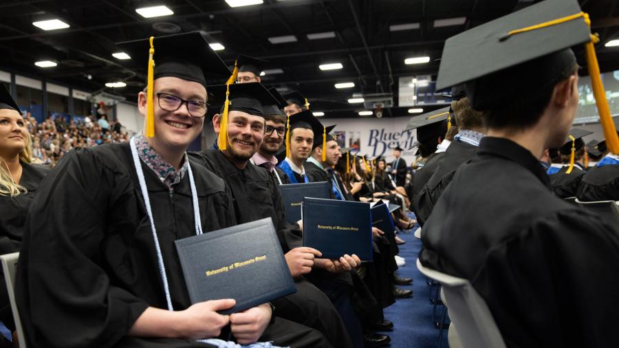 Graduates proudly show off their diplomas during one of the ceremonies at Johnson Fieldhouse.