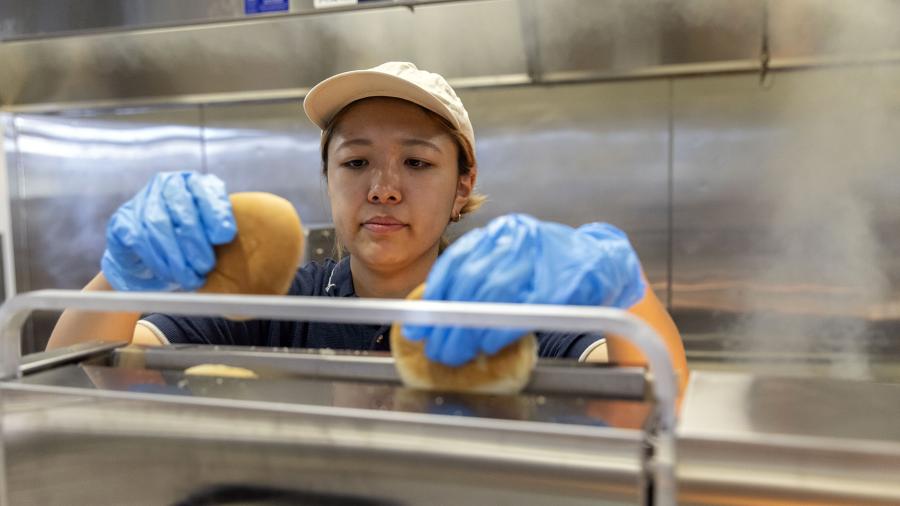 A student in UW-Stout Dining Services prepares toasted buns for burgers at Merle M. Price Commons cafeteria.