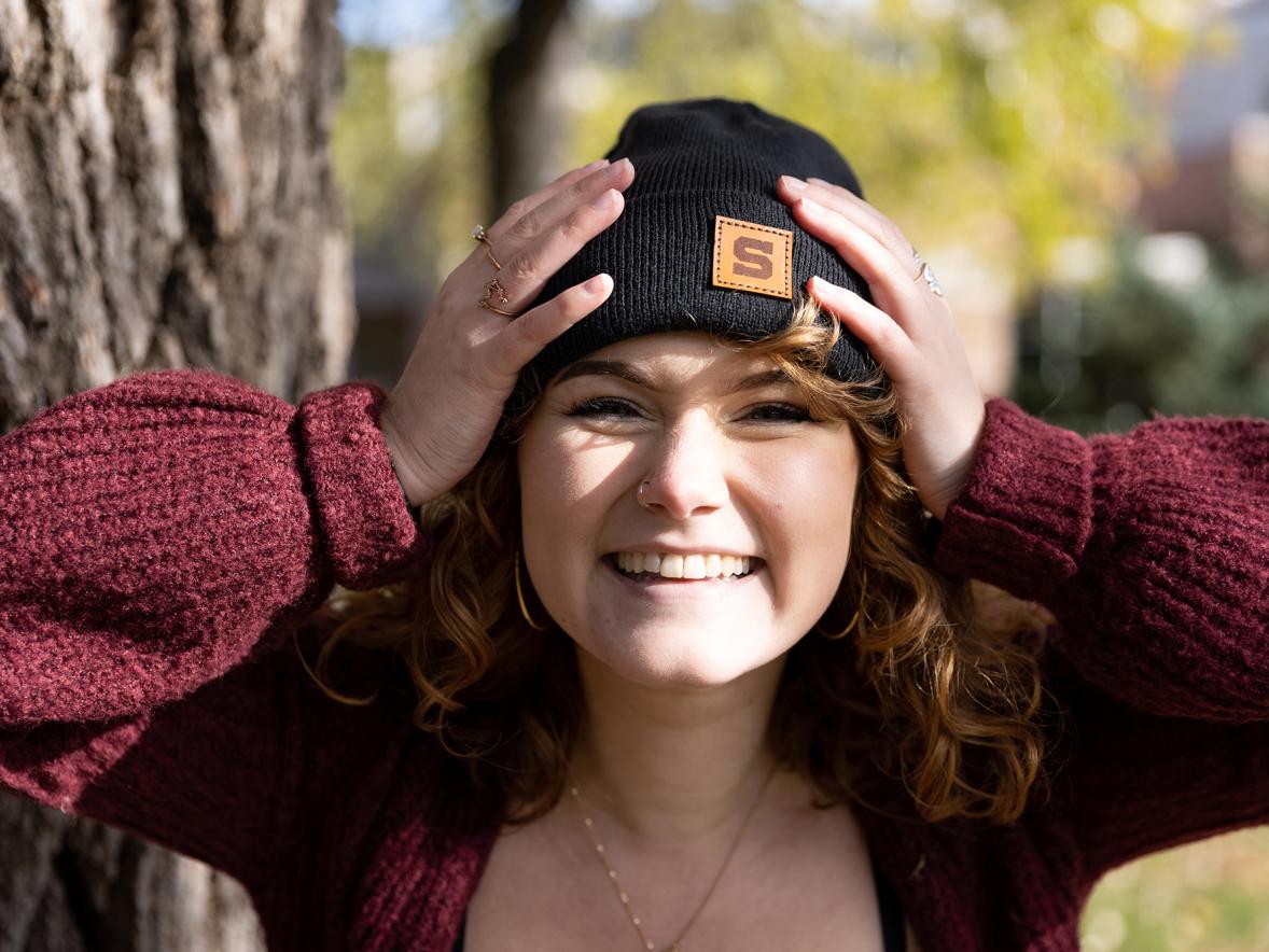 UW-Stout Ambassador Willa Rodencal models one of the Stout Impact Project stocking caps that are being sold to raise money for the Student Emergency Fund. /Chris Cooper photo