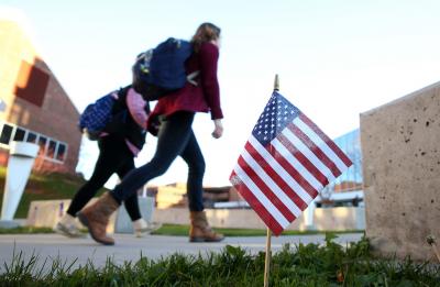 UW-Stout students walk across campus amid American flags, celebrating our veterans.