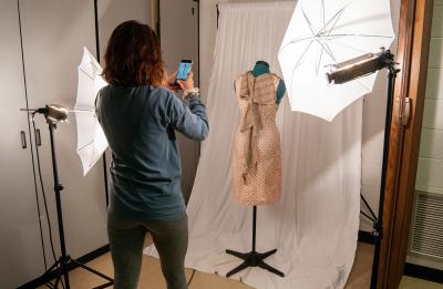A student photographs her work in a fashion and retail lab.