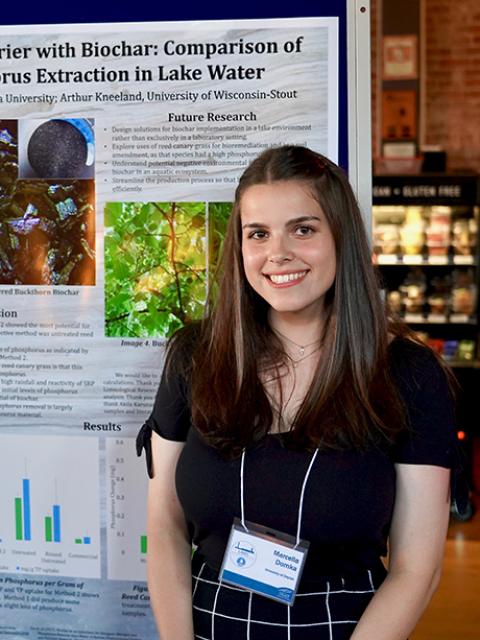 Marcella Domka posing in front of her research poster