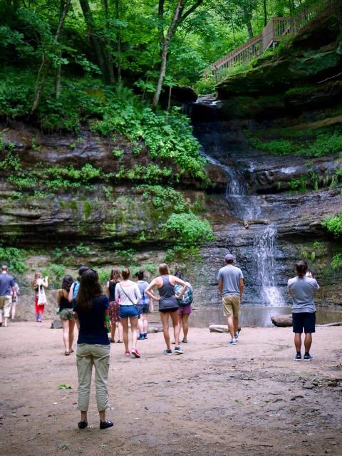 Students from UW-Stout’s LAKES REU program visit the Devil’s Punchbowl waterfall near campus.